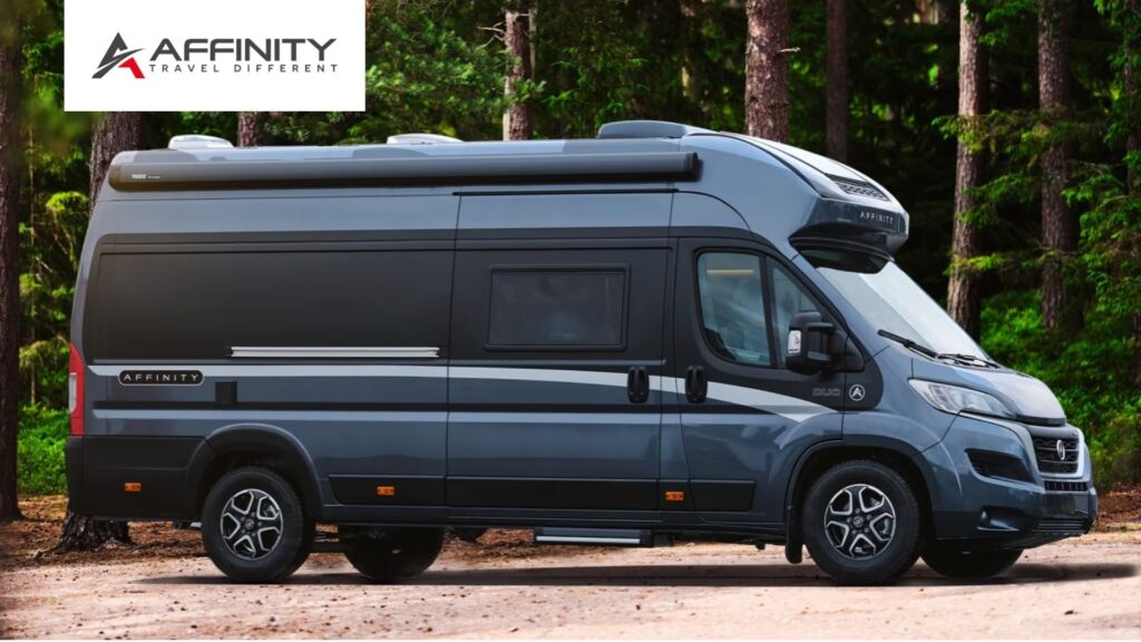 Affinity husbil parkerad i en skogsmiljö, med företagets logotyp och slogan 'Travel Different' i övre hörnet. En elegant och modern campervan för äventyrliga resor.